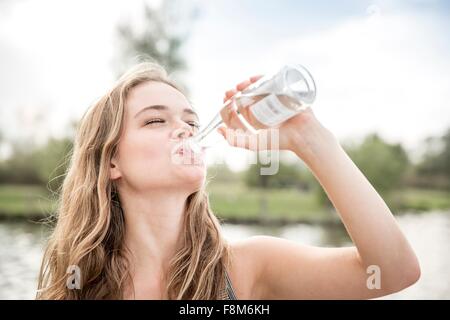 Junge Frau Trinkwasser aus der Flasche, im freien Stockfoto