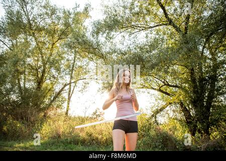 Junges Mädchen in ländlicher Umgebung mit Hula-Hoop, Lächeln Stockfoto