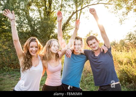 Porträt der Gruppe von Freunden in ländlicher Umgebung, Arme heben, Lächeln Stockfoto