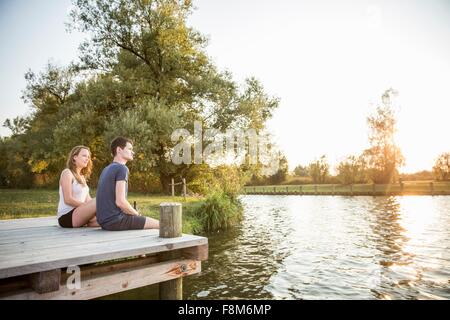 Junges Paar sitzt an einem Anlegesteg, relaxen Stockfoto