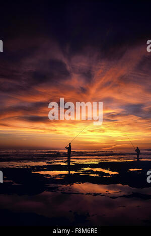 Angeln in der Abenddämmerung am Strand. Praia da Oura. Albufeira. Die Algarve. Portugal. Europa Stockfoto