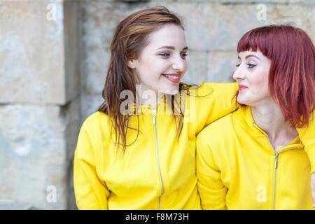 Junge Frauen, Lächeln, Wand Stein im Hintergrund Stockfoto