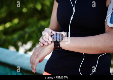 Schuss von jungen weiblichen Läufer Einstellung Smartwatch beschnitten Stockfoto