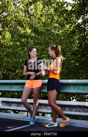 Zwei junge Damen im Chat auf Parkplatz Stockfoto