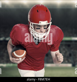 Zusammengesetztes Bild der amerikanischen Football-Spieler läuft mit dem ball Stockfoto