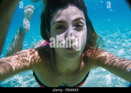 Junge Frau, die unter Wasser schwimmen im Ozean Stockfoto