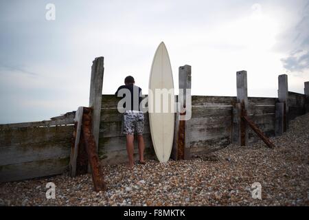 Surfer mit Surfbrett Holzzaun gelehnt Stockfoto