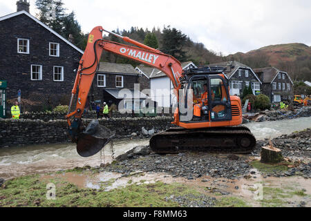 Glenridding, Cumbria, 10. Dezember 2015. Großbritannien Wetter.  Über Nacht Starkregen verursacht mehr Überschwemmungen als den Fluss, der durch das Dorf wieder übergelaufen.  Rettungsdienste hießen in der letzten Nacht, Menschen in Sicherheit zu helfen, als Volkspartei Besitzungen einschließlich Weihnachtsschmuck hinunter die Straße gewaschen wurden. Bagger wurden heute Morgen zur versuchen und Baggern Schutt aus dem Fluss in einem Versuch zu verhindern, dass weitere Überschwemmungen.  Im nahe gelegenen Patterdale könnte Beweis für die Kraft des Wassers vom Sturm Desmond auch gesehen werden, wo Hochwasser durch die Fahrbahn geplatzt. Bildnachweis: David Forster/Alamy Live Ne Stockfoto