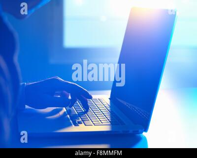 Mann am Laptop-Computer eingeben Stockfoto