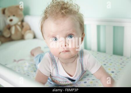 Porträt von Babymädchen im Kinderbett liegen Stockfoto