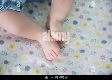 Baby Mädchen hinlegen, Füße im Fokus Stockfoto