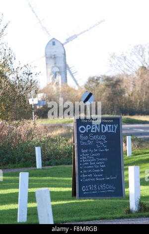 Eine A-Board vor einem Land Pub mit einer Windmühle im Hintergrund Stockfoto