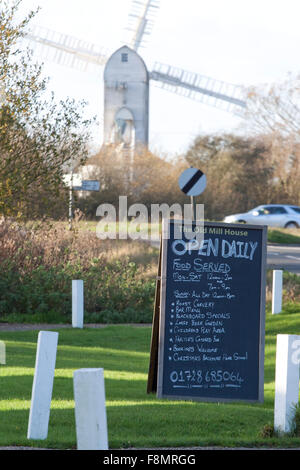 Eine A-Board vor einem Land Pub mit einer Windmühle im Hintergrund Stockfoto