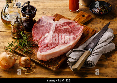 Rohes Frischfleisch t-Bonesteak und Gewürze auf hölzernen Hintergrund Stockfoto