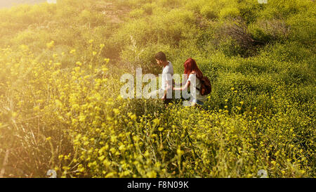 Aufnahme des jungen Paares zu Fuß durch Rasen auf einem Gipfel. Junger Mann und Frau Wandern an einem Sommertag. Stockfoto