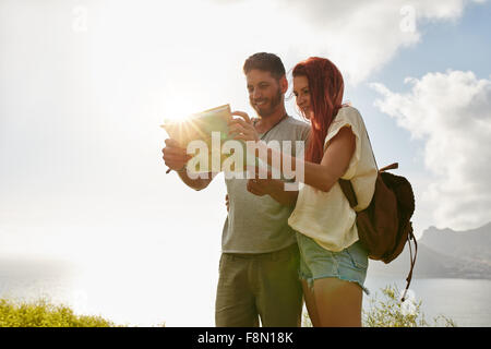 Mann und Frau auf der Suche nach dem Weg auf der Karte. Paar anzuhalten, um ihre Karte zu überprüfen, während des Gehens auf Land. Stockfoto