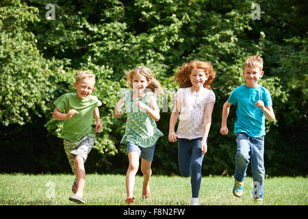 Gruppe von Kindern läuft auf Kamera auf Spielplatz Stockfoto