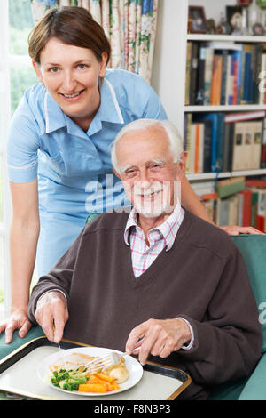 Pflegeperson das Mittagessen für den älteren Menschen Stockfoto