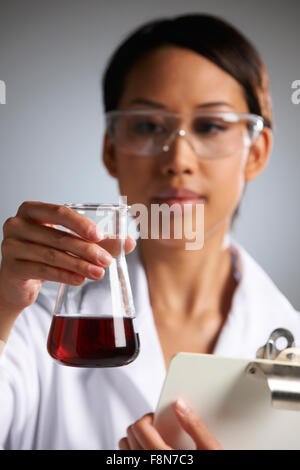 Wissenschaftler mit Zwischenablage Prüfung Becher Stockfoto