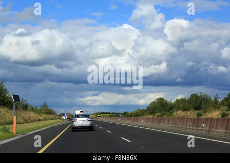 Schöne Gewitterwolken über Landstraßen in Irland. Stockfoto