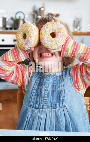 Junge Mädchen, Gläser mit bunten Donuts Stockfoto