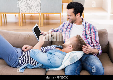 Gay paar entspannen auf der Couch mit tablet Stockfoto