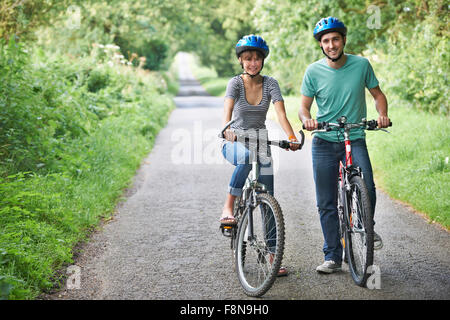 Junges Paar Radtouren entlang der Landstraße Stockfoto