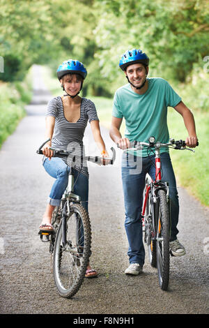 Junges Paar Radtouren entlang der Landstraße Stockfoto