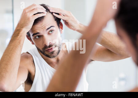 Konzentriert Man seine Haare im Spiegel zu betrachten Stockfoto