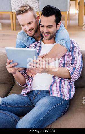 Gay paar entspannen auf der Couch mit tablet Stockfoto