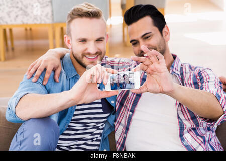 Entspannen Sie sich auf die Couch nehmen Selfie Gay paar Stockfoto