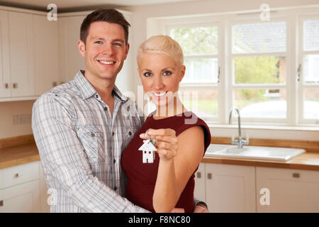 Junges Paar Betrieb Schlüssel zu neuen Haus begeistert Stockfoto