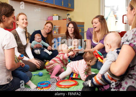 Gruppe von Müttern mit Babys bei Spielgruppe Stockfoto