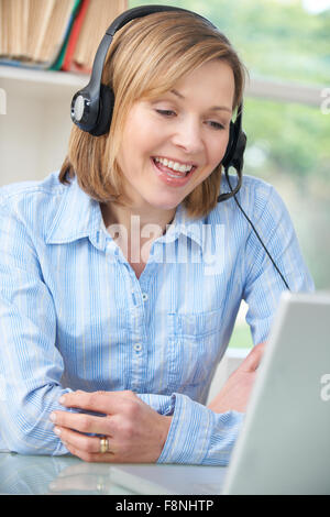 Applying Frau sprechen Online über Kopfhörer Stockfoto