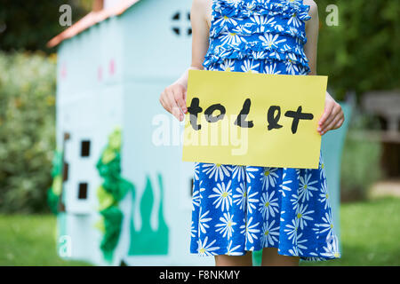 Kleines Mädchen hält Schild Spielhaus lassen Stockfoto