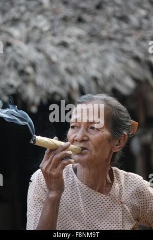 Asiatische Frau raucht eine Zigarre Aufnahme in einem kleinen Dorf in der Nähe von Heide, in Myanmar Burma, wo eine Frau Zigarren durch innovative tut Stockfoto