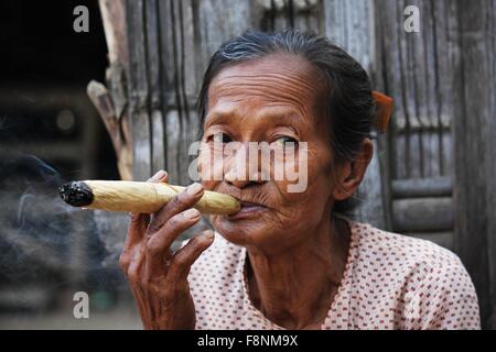 Frau raucht eine Zigarre Aufnahme in einem kleinen Dorf in der Nähe von Heide, in Myanmar Burma, wo eine Frau von sich selbst und Sm Zigarren tut Stockfoto