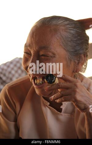 Alte asiatische Frau einer handgemachten Zigarre Stockfoto