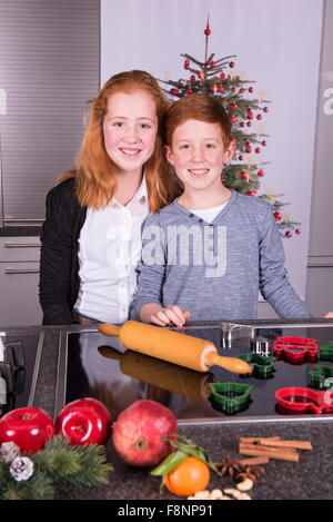 zwei Kinder in der Küche und bereitet Weihnachtsbäckerei Stockfoto