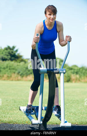 Applying Frau mit Outdoor-Fitnessgeräte Stockfoto