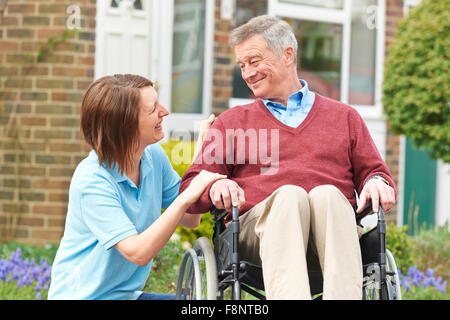 Pflegeperson mit Senior Mann im Rollstuhl Stockfoto