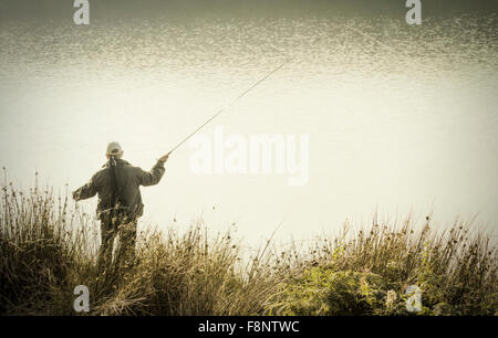 Mann Fliegenfischen am Stausee Stockfoto