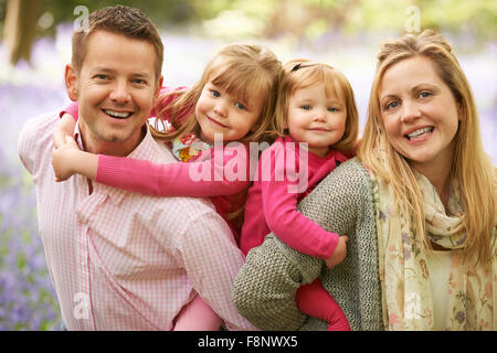 Familie zu Fuß durch Bluebell Woods zusammen Stockfoto