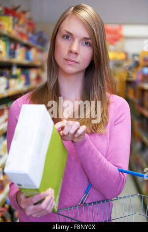 Frau, Prüfung, Kennzeichnung auf Box im Supermarkt Stockfoto