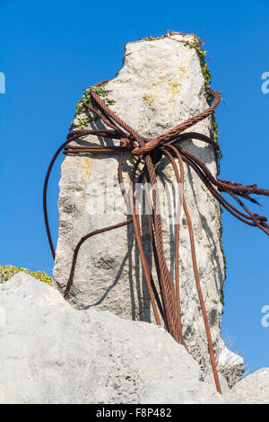 Alten rostigen Eisen Kabel geloopt um einen Kalksteinfelsen in einem Steinbruch. Stockfoto