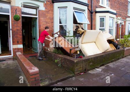 Cumbrian Überschwemmungen. Mann, der seine Flut beschädigt Eigenschaft ergriffen, externen überfluteten Häuser. Carlisle, Cumbria, UK. Stockfoto