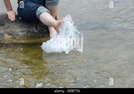 Frau spritzt Füße im Meer Stockfoto