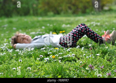 Mädchen liegend auf dem Rasen im Frühling Stockfoto