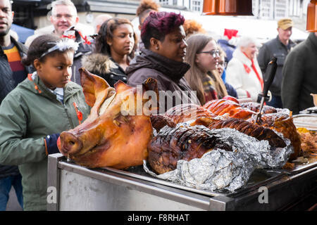 Eine Schweine-Kopf auf einem Stall als Kunden Warteschlange für heiße Schweinefleisch rollt an Bridgnorth Weihnachten Markt, Shropshire, England, UK Stockfoto