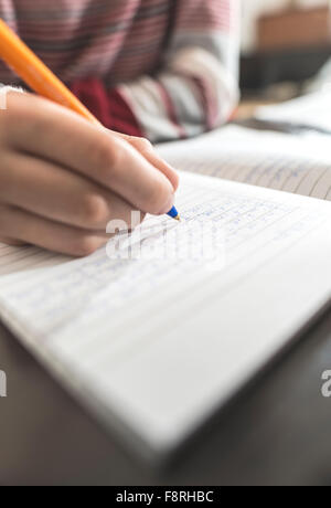 Junge in ein Notizbuch schreiben Stockfoto